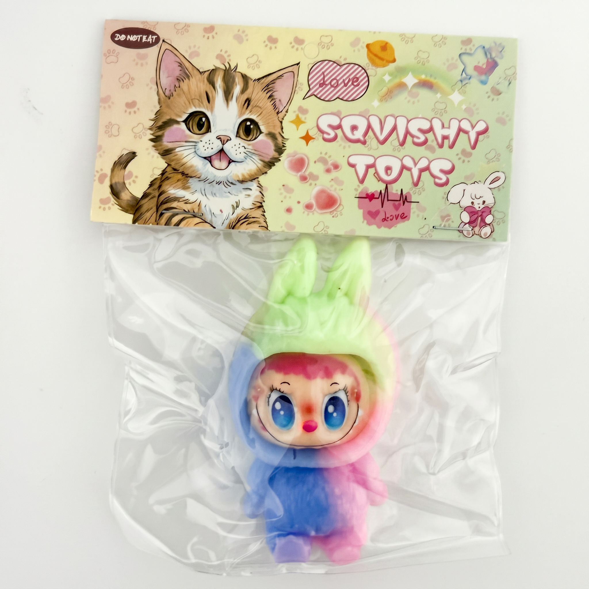 Squishy toy with colorful design in front of Squishy Toys packaging featuring a cat illustration.